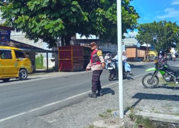 Bhabinkamtibmas Polsek Kuala Turun Atur Lalu Lintas, Bantu Pelajar Menyeberang