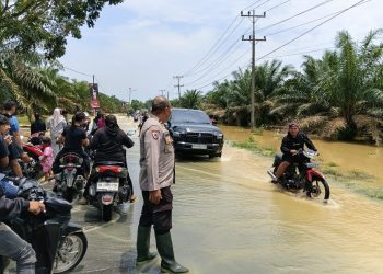 Banjir Rendam Jalan Sumor bor-Tanjung Selamat, Polsek Padang Tualang Sigap Atur Lalu Lintas
