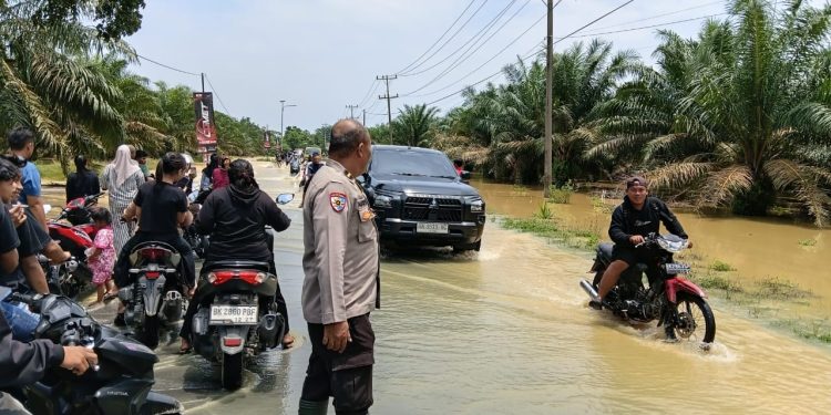 Banjir Rendam Jalan Sumor bor-Tanjung Selamat, Polsek Padang Tualang Sigap Atur Lalu Lintas
