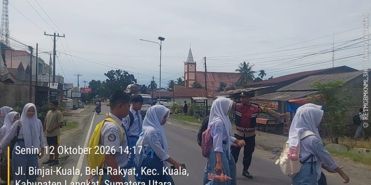 Polisi Hadir di Jam Sibuk, Bhabinkamtibmas Polsek Kuala Bantu Siswa Menyeberang Jalan